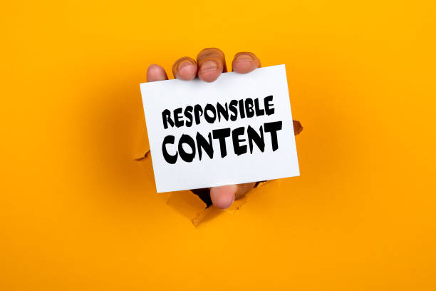istock Responsible Content. Note paper in a woman's hand. Yellow background 1302454638
