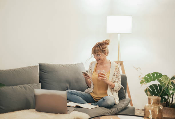 istock Young female adult checking smartphone from the sofa 1302454969