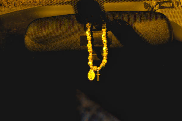 Rosary bracelet hanging on car mirror for protection from harm