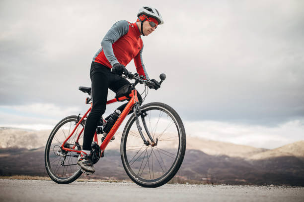 istock Professional male cyclist riding bicycle on road 1302457373