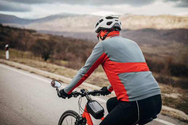 istock Professional male cyclist riding bicycle on road 1302457385