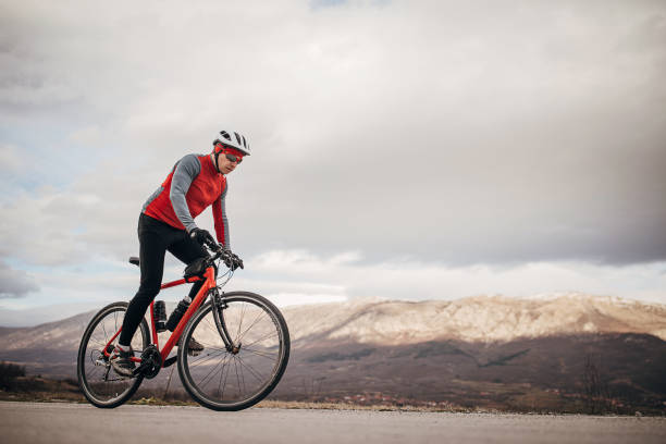 istock Professional male cyclist riding bicycle on road 1302457405