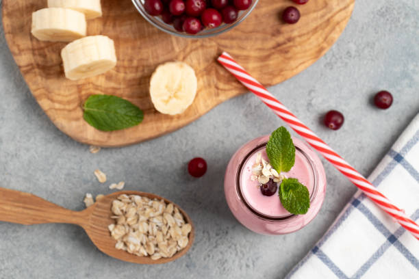 hausgemachter joghurt-smoothie mit banane, preiselbeere und haferflocken, ansicht von oben, flach liegen - healthy lifestyle cranberry healthy eating milk shake stock-fotos und bilder