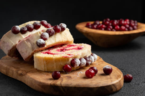 istock Homemade biscuit sweet roll with cranberries and cream on a black table 1302457632