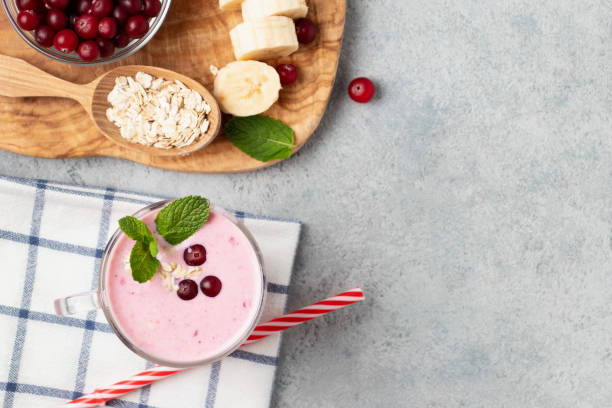 frullato di yogurt fatto in casa con banana, mirtillo rosso e farina d'avena, spazio di copia, vista dall'alto, lay piatto - healthy lifestyle cranberry healthy eating milk shake foto e immagini stock