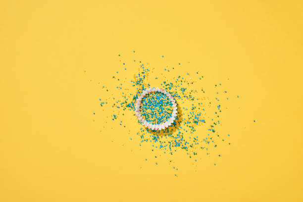 istock Easter cake baking dish with candy and scattered confectionery topping dressing on yellow background. Celebratory background concept. Mock up. Space for text. 1302459142