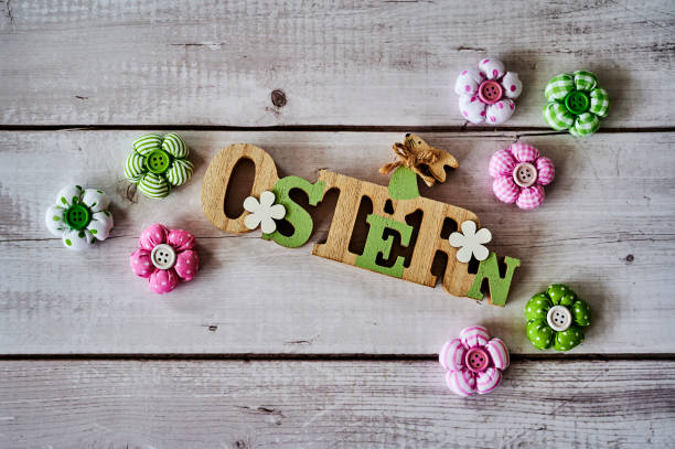Wooden sign with an Easter bunny with flowers as decoration. The Text is German for Easter.