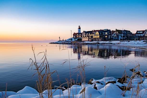 istock Urk Netherlands lighthouse during winter with snow covered coastline, Urk view at the lighthouse snowy landscape winter weather in Holland 1302462627