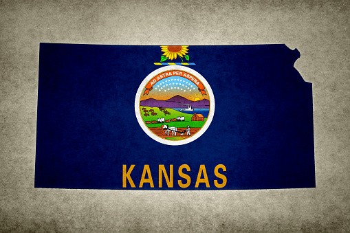 Grunge map of the state of Kansas (USA) with its flag printed within its border on an old paper.