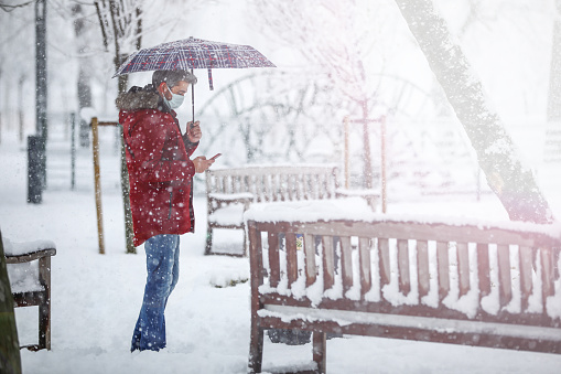 Man in Red Coat, Snowfall And Messaging With Wireless Technology