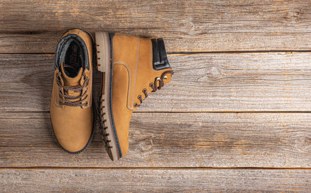 istock Yellow winter boots on a wooden background 1302464411