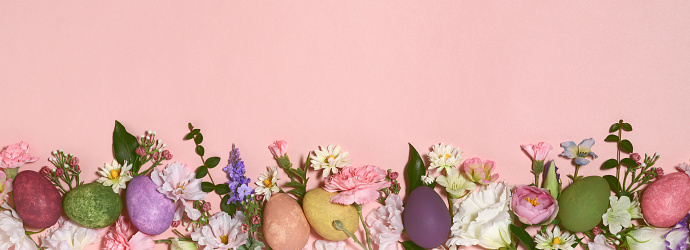 Multi colored Easter eggs with flowers on pink background