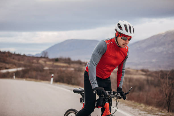 istock Professional cyclist riding bicycle on road 1302465544