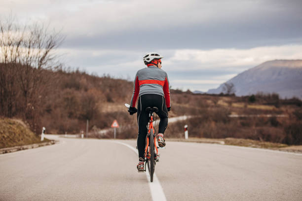 istock Professional male cyclist riding bicycle on road 1302465560