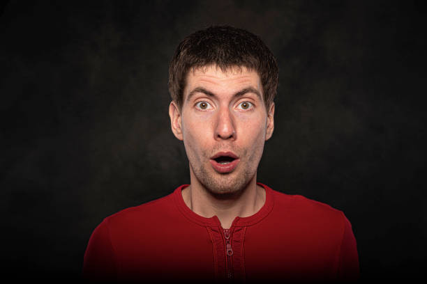 istock Funny young guy portrait isolated on dark background 1302466565