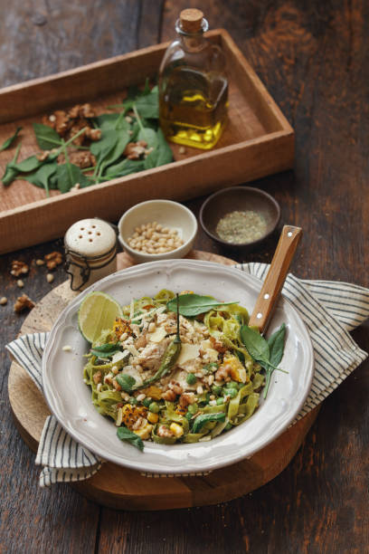 Leftover Turkey Green Pasta with Basil-Mint Pesto Leftover turkey green pasta with basil-mint pesto, sweet corn, green peas, seeds and microgreen. Close-up composition on dark wooden background. spinach pasta stock pictures, royalty-free photos & images