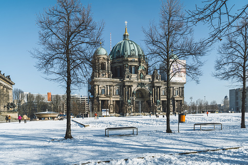 snow capped  park around the Berlin Cathedral under blue winter sky