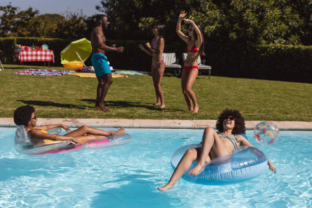 istock Diverse group of friends having fun and dancing at a pool party 1302468720