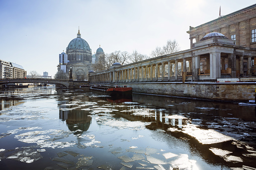 ice floating on spree river in berlin with cathedral in the background