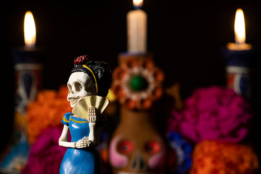 Day of the Dead offering from central Mexico with papel picado, veladoras, photography, flowers and bread of the dead
