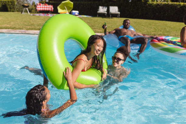 istock Diverse group of friends having fun playing on inflatables in swimming pool 1302470130