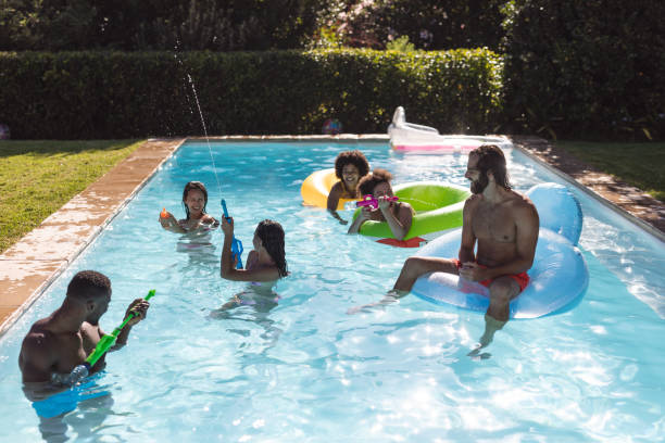 istock Diverse group of friends having fun playing on inflatables in swimming pool 1302470647