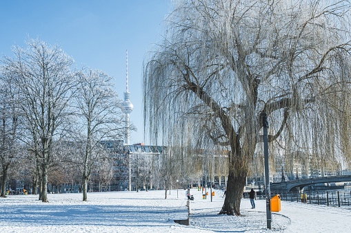 snowy park alongside the river in central berlin with tv-tower in the background on clear sunny winter day