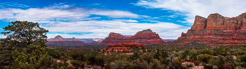 Panoramic image of the rock formations and vegetation found on the hiking trails in Sedona, Arizona.