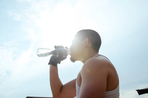 istock Young exhausted athlete drinking fresh water to cool off during a running track. 1302471942