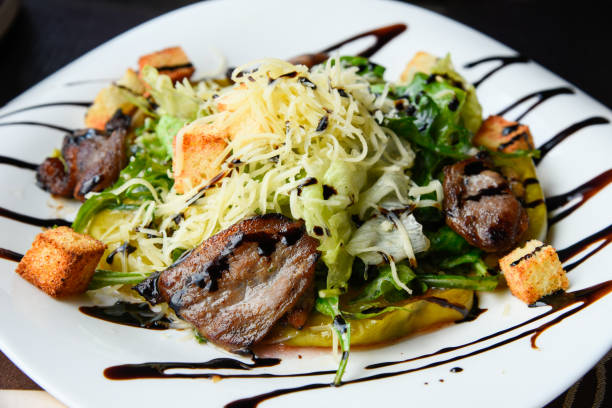 istock Smoked duck breast with cheese and fresh vegetable salad. 1302472138