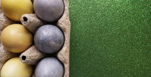 istock painted eggs for easter yellow and gray in a cardboard egg holder 1302473257