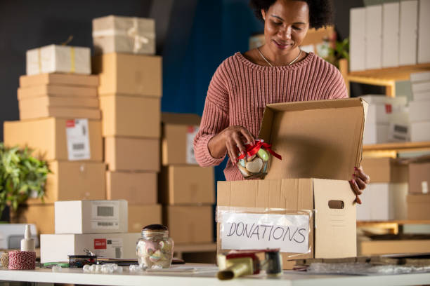 istock Woman putting a jar of candy in a ''donations'' box 1302474285