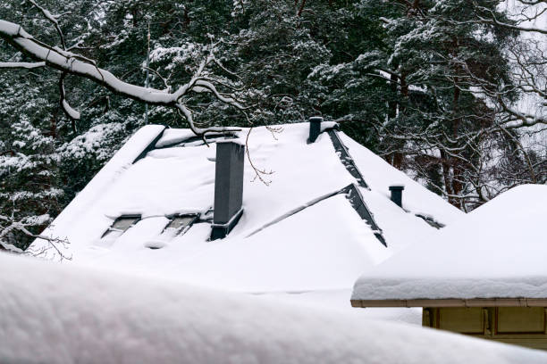 istock White snow is falling on the roof covered with snow. 1302475687