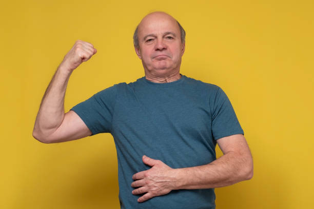 istock Senior man showing arms muscles smiling proud. 1302475755