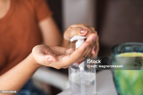Young Woman Sanitizing Her Hands Before Snack At A Restaurant Stock Photo - Download Image Now