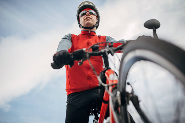 One man, professional male cyclist riding bicycle outdoors alone.