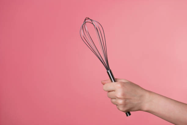 istock Whisk for whipping cream, making desserts. A woman's hand and kitchen tools. 1302478483