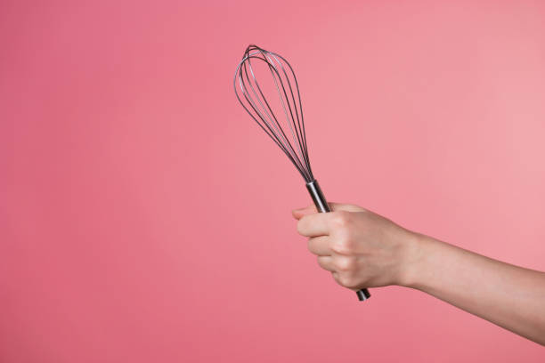 istock Whisk for whipping cream, making desserts. A woman's hand and kitchen tools. 1302478488