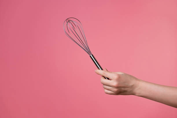istock Whisk for whipping cream, making desserts. A woman's hand and kitchen tools. 1302478489