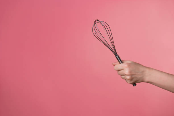 istock Whisk for whipping cream, making desserts. A woman's hand and kitchen tools. 1302478494