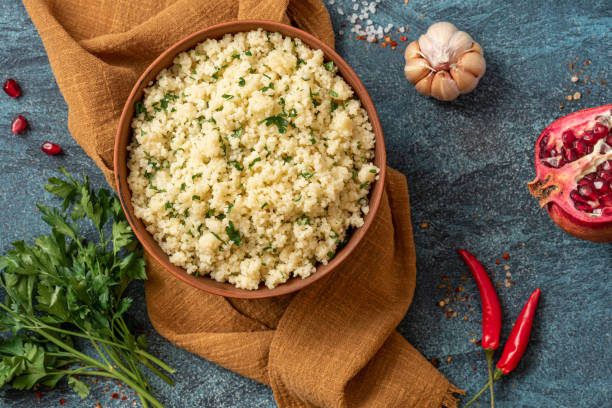 istock Cooked couscous with parsley on a dark background top view 1302478784