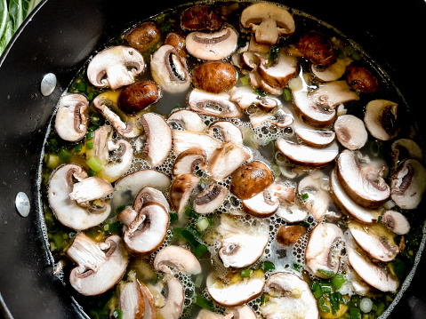 A Simmering Pot Of Shrimp Pho Soup With Green Onion, Mushrooms, Fresh Garlic, Bok Choy, Jalapeno, Lemon Slices And Cilantro Over Pad Thai  Noodles