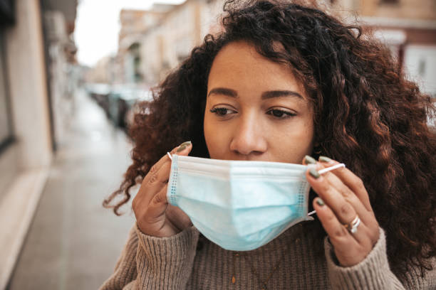 istock Woman wearing a surgical face mask 1302479391