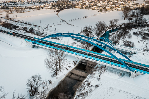 Blue road and railway bridge in winter scenery next to Opole city.