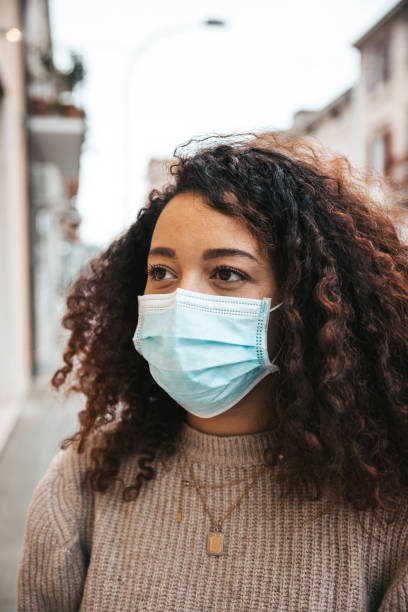 istock Woman wearing a surgical face mask 1302480793