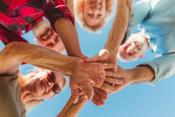 Senior people holding hands together in the middle stock photo