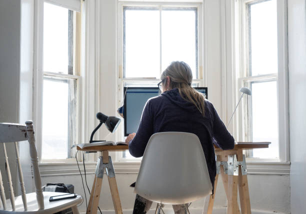 An authentic real life scene of a woman working from a temporary home office.