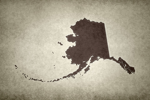 Grunge map of the state of Alaska (USA) printed within on an old paper.