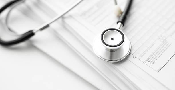 istock Stack of report medical documents and stethoscope isolated on white background 1302483467