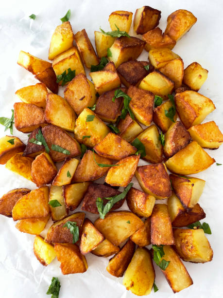 roasted potatoes with parsley close-up of roasted potatoes with parsley fried potato stock pictures, royalty-free photos & images